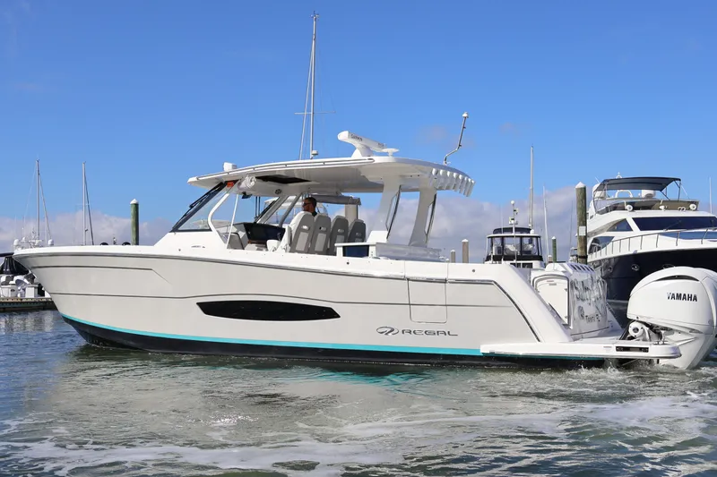 Slide: The Image of 2022 Regal 38 SAV boat docked, featuring Yamaha engines and sleek design. - 9