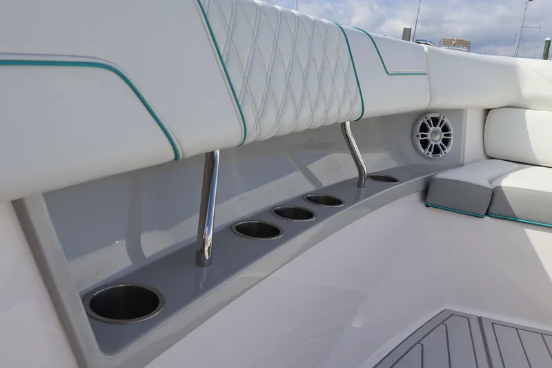 Slide: The Image of 2022 Regal 38 SAV boat interior with cushioned seating and built-in cup holders. - 92