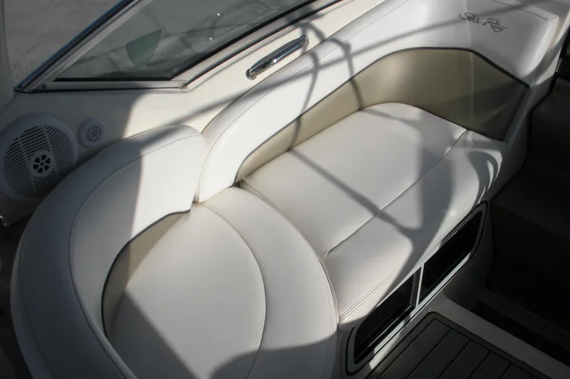 Slide: The Image of 2006 Sea Ray 260 Sundancer boat interior with white cushioned seating. - 14