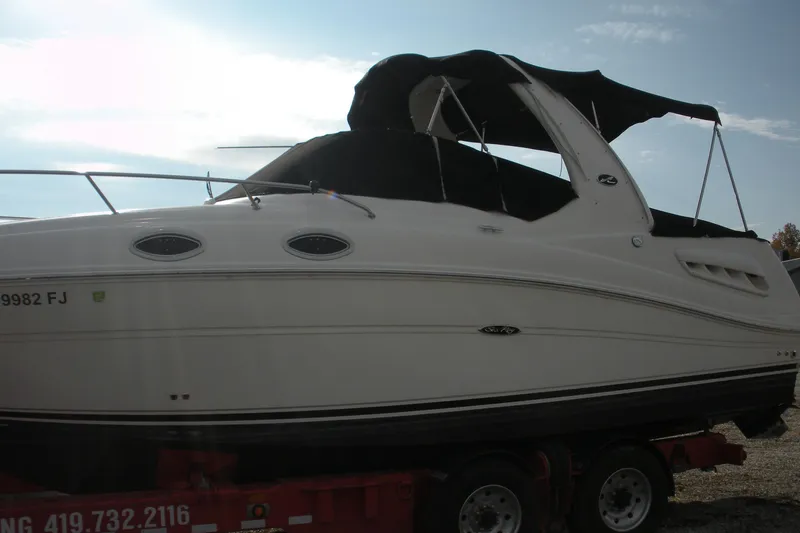 Slide: The Image of 2006 Sea Ray 260 Sundancer boat on trailer, side view with black canopy. - 2