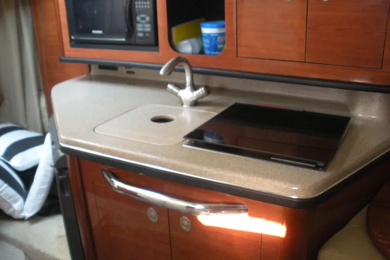 Slide: The Image of Compact kitchen area in 2006 Sea Ray 260 Sundancer boat with sink and stove. - 4