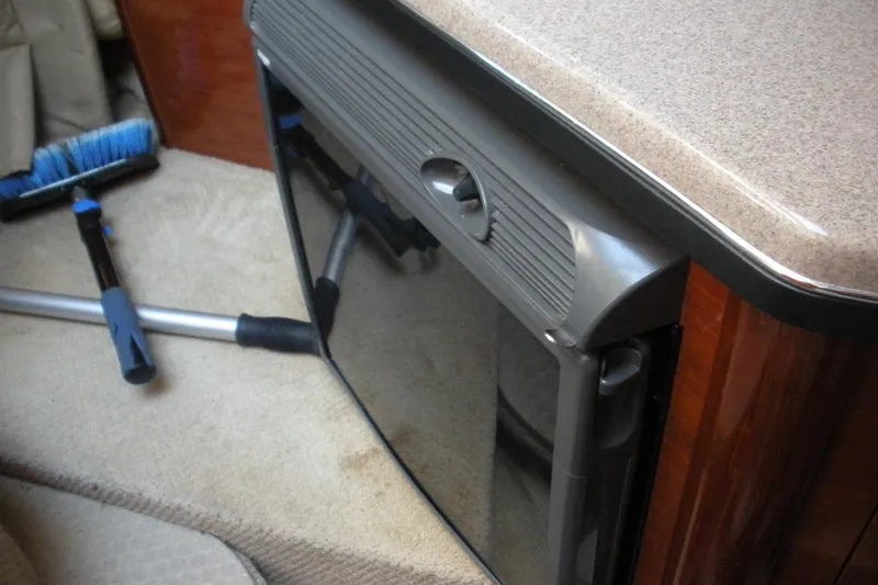 Slide: The Image of Interior of 2006 Sea Ray 260 Sundancer with compact fridge and cleaning tools. - 5