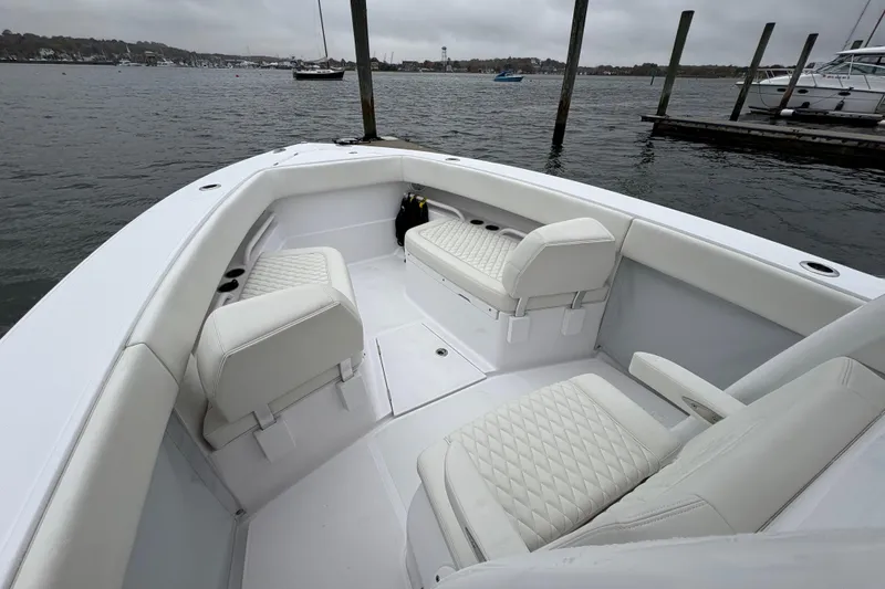 Slide: The Image of 2023 Jupiter 30 boat interior with white seating, docked by the water. - 16