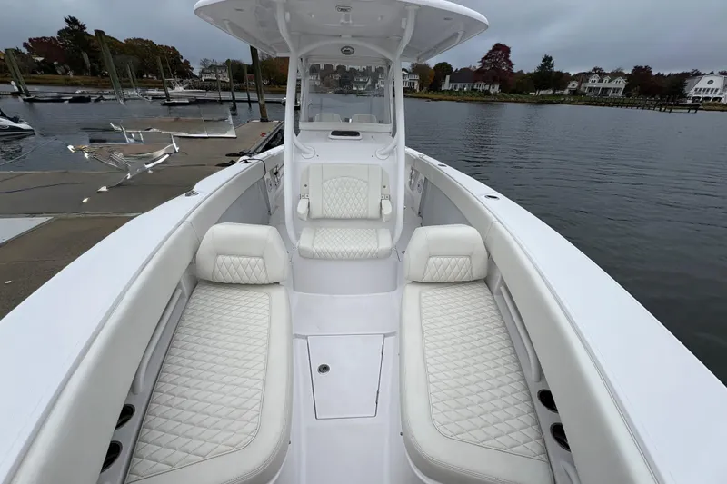 Slide: The Image of 2023 Jupiter 30 boat with luxurious white seating, docked by a serene waterfront. - 19