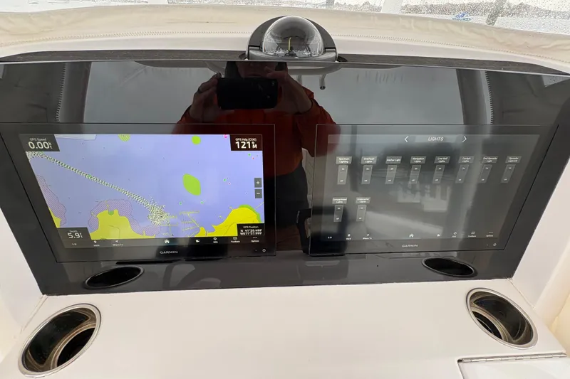 Slide: The Image of 2023 Jupiter 30 boat dashboard with dual Garmin displays showing navigation and control settings. - 25