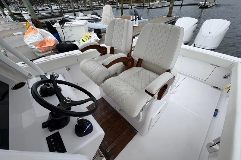 Slide: The Image of Luxury seating and steering area on 2023 Jupiter 30 boat at marina. - 26