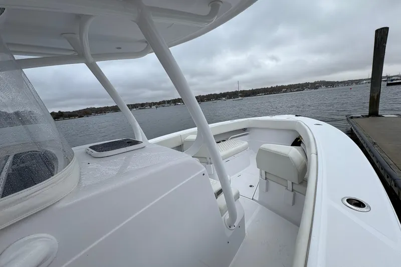 Slide: The Image of 2023 Jupiter 30 boat docked on a cloudy day, showcasing sleek design and spacious seating. - 29