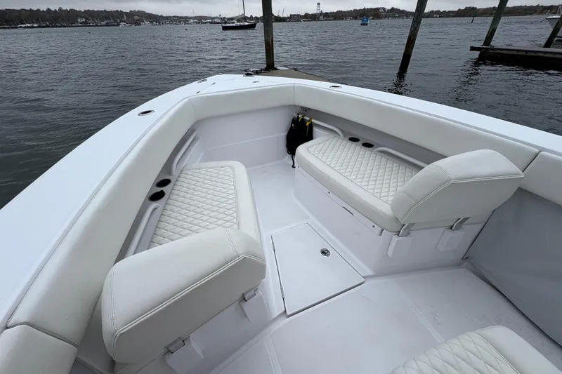 Slide: The Image of 2023 Jupiter 30 boat interior with white seating, docked by the water. - 32