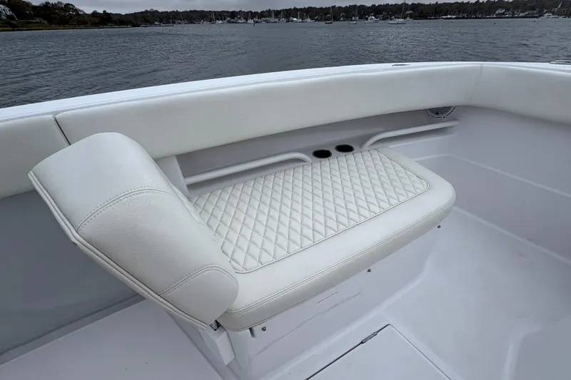 Slide: The Image of Luxurious white seating on 2023 Jupiter 30 boat, featuring diamond-pattern upholstery. - 34