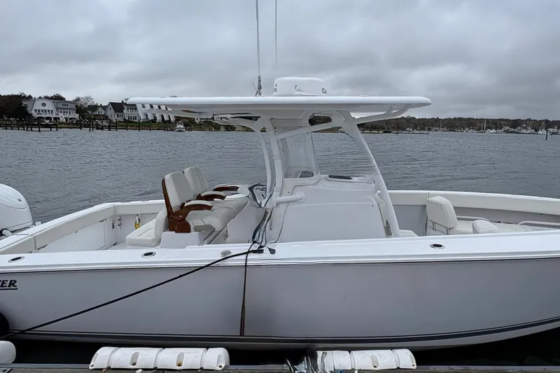 Slide: The Image of 2023 Jupiter 30 boat docked by a calm waterfront under cloudy skies. - 40