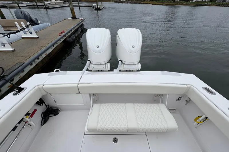Slide: The Image of 2023 Jupiter 30 boat with dual engines, docked at marina, featuring white seating. - 48