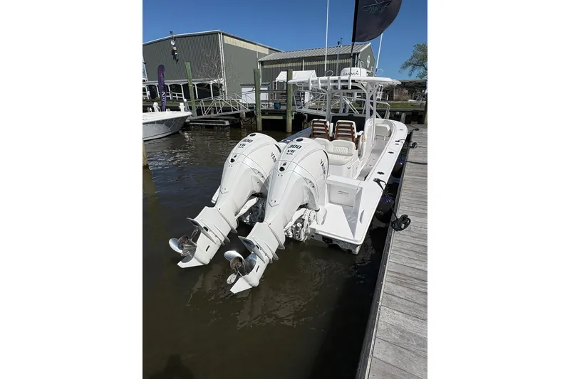 Slide: The Image of 2023 Jupiter 30 boat with dual outboard engines docked at a marina. - 56