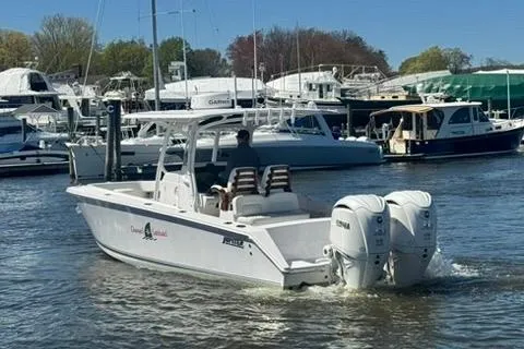 Slide: The Image of A 2023 Jupiter 30 boat with dual engines cruising in a marina. - 57