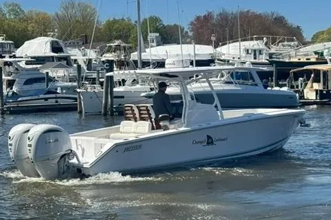 Slide: The Image of 2023 Jupiter 30 boat cruising in a marina with multiple yachts docked. - 62