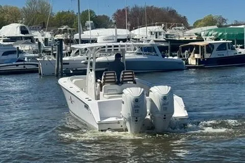 Slide: The Image of 2023 Jupiter 30 boat with twin engines navigating a marina. - 63