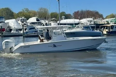 Slide: The Image of A 2023 Jupiter 30 boat cruising in a marina with other boats docked. - 64