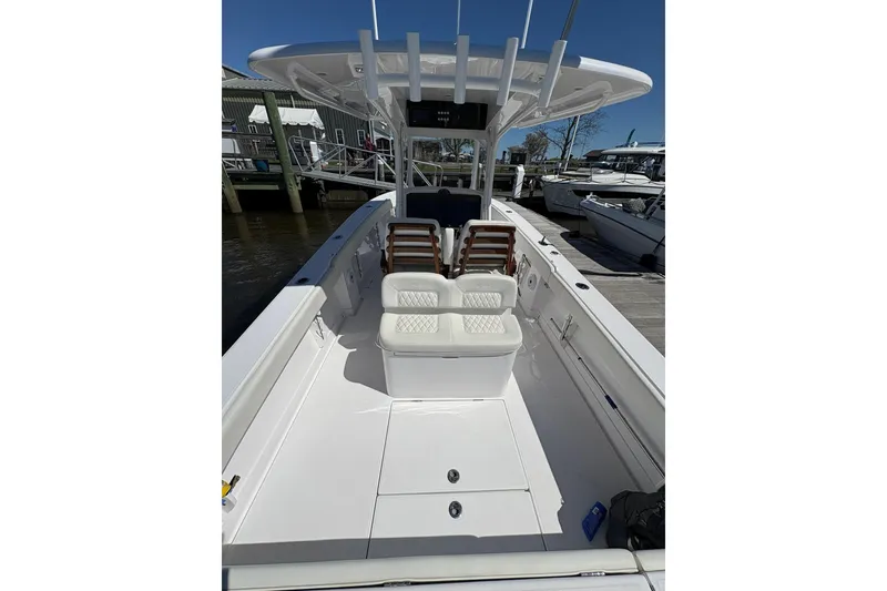 Slide: The Image of A 2023 Jupiter 30 boat navigating a marina with multiple docked vessels. - 66