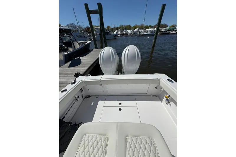 Slide: The Image of 2023 Jupiter 30 boat navigating marina waters with other vessels docked nearby. - 73