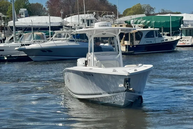Slide: The Image of 2023 Jupiter 30 boat helm with modern controls and steering wheel, docked at marina. - 80