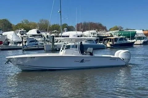 Slide: The Image of 2023 Jupiter 30 boat cruising in a marina with other vessels in the background. - 82