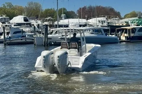 Slide: The Image of 2023 Jupiter 30 boat interior with white seating at a marina dock. - 87