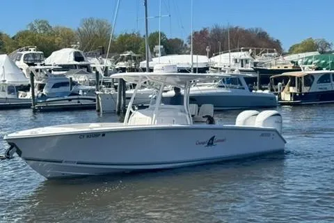 Slide: The Image of 2023 Jupiter 30 boat cruising in a marina with other vessels in the background. - 89