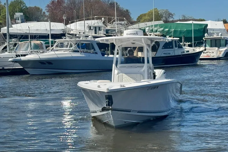 Slide: The Image of 2023 Jupiter 30 boat interior with cushioned seating, docked at marina. - 91