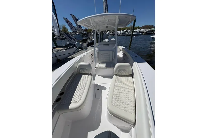 Slide: The Image of 2023 Jupiter 30 boat cruising in a marina with other vessels in the background. - 92