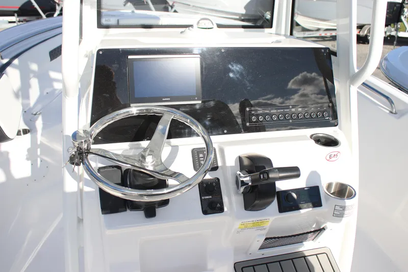 Slide: The Image of 2026 Tidewater 220 CC Adventure boat dashboard with steering wheel and control panel. - 4