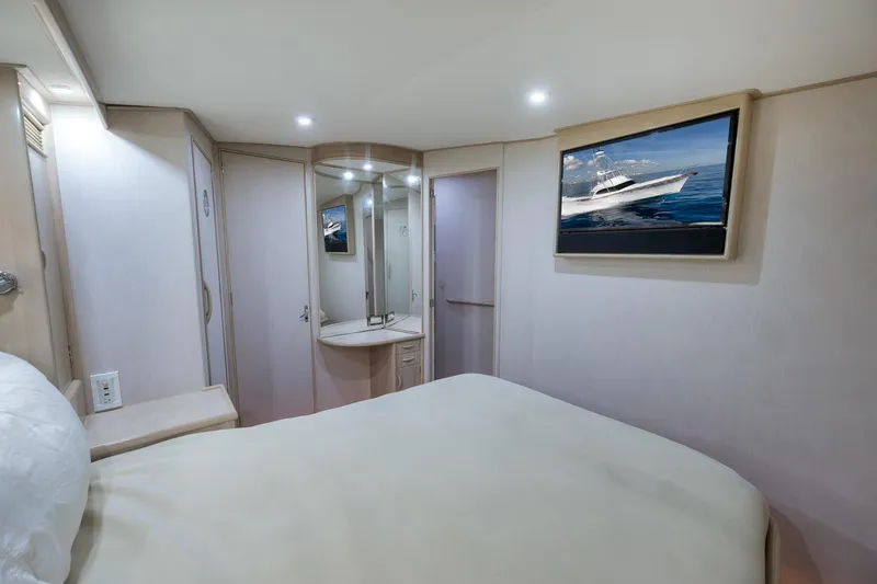 Slide: The Image of Luxurious 1998 Rybovich Convertible yacht bedroom with modern decor and wall-mounted TV. - 10