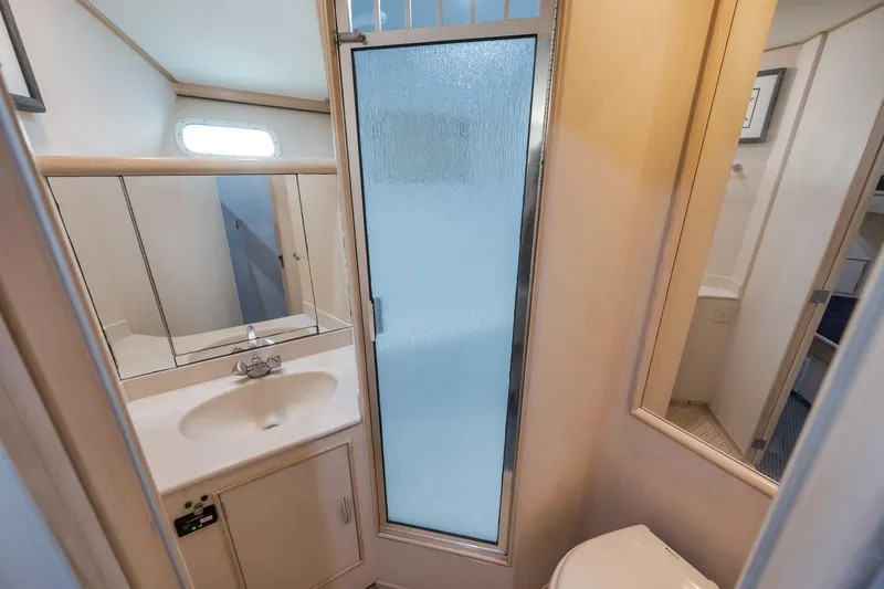 Slide: The Image of Bathroom interior of 1998 Rybovich Convertible yacht with sink, mirror, and shower. - 13