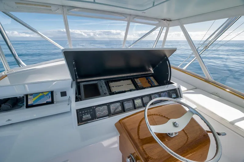 Slide: The Image of 1998 Rybovich Convertible yacht helm with navigation equipment, steering wheel, and ocean view. - 17