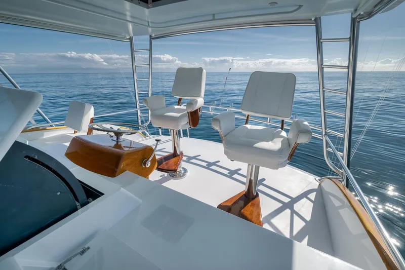 Slide: The Image of 1998 Rybovich Convertible yacht helm with ocean view, featuring two white captain chairs. - 22