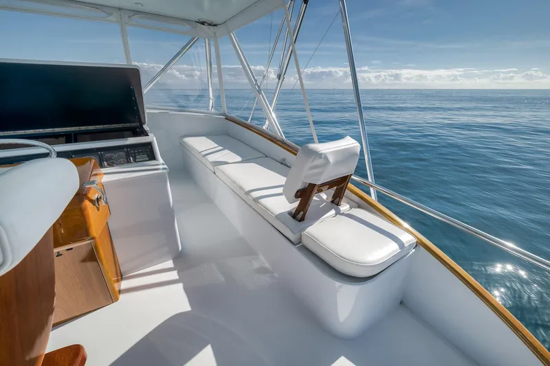 Slide: The Image of 1998 Rybovich Convertible yacht interior with ocean view, featuring white seating and helm station. - 23