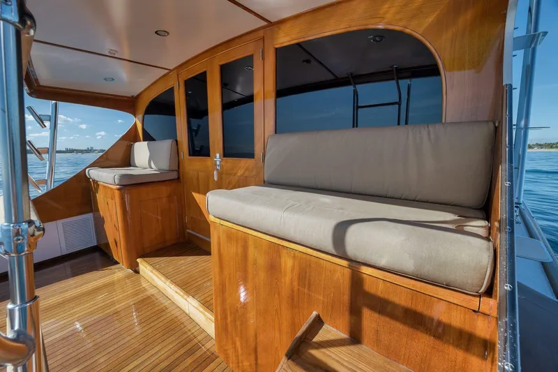 Slide: The Image of 1998 Rybovich Convertible yacht interior with wooden seating and ocean view. - 29