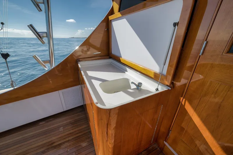 Slide: The Image of 1998 Rybovich Convertible yacht interior with wooden cabinetry and sink, overlooking the ocean. - 30