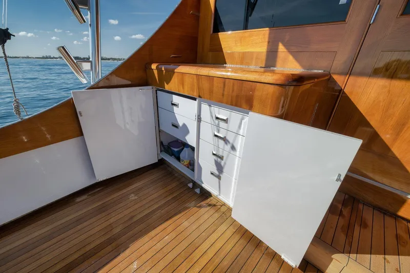 Slide: The Image of 1998 Rybovich Convertible yacht interior with open storage cabinets and wooden flooring. - 31