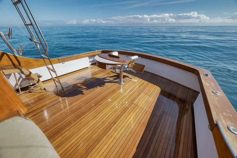 Slide: The Image of 1998 Rybovich Convertible yacht deck with wooden finish, ocean view, and fishing chair. - 34