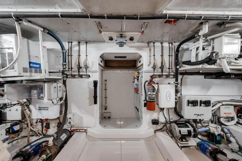 Slide: The Image of Engine room of a 1998 Rybovich Convertible yacht, featuring various mechanical systems and equipment. - 38