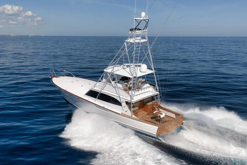 Slide: The Image of 1998 Rybovich Convertible yacht cruising on open sea under clear blue sky. - 45