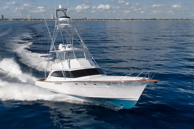 Slide: The Image of 1998 Rybovich Convertible yacht cruising on open water under a clear sky. - 46