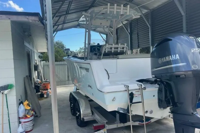 Slide: The Image of 2021 Sportsman Open 232 Center Console boat on trailer, parked outdoors. - 2