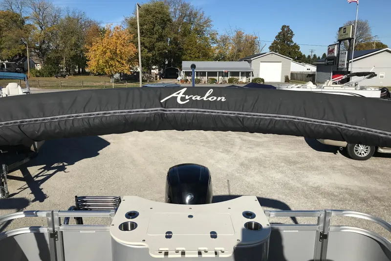 Slide: The Image of 2023 Avalon LSZ Rear Fish boat with covered seating, parked outdoors. - 15
