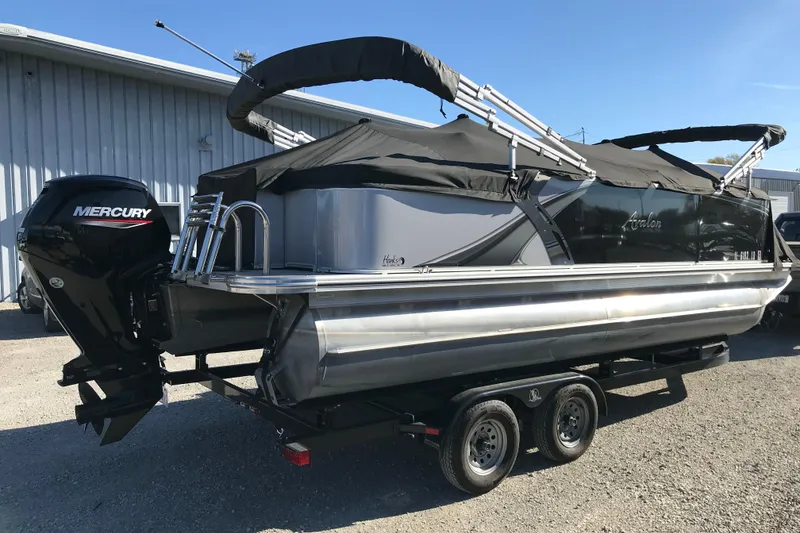 Slide: The Image of 2023 Avalon LSZ Rear Fish pontoon boat with Mercury engine, parked on a trailer. - 29