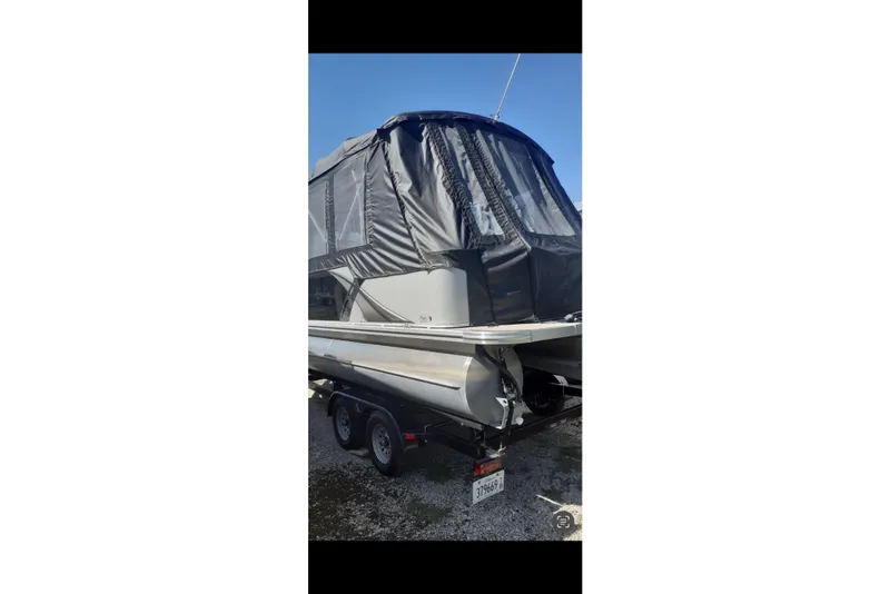 Slide: The Image of 2023 Avalon LSZ Rear Fish pontoon boat with protective cover on trailer. - 34