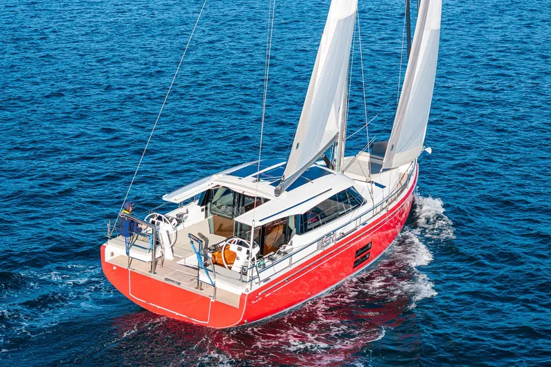 The Image of 2024 Moody 41ds sailboat with red hull sailing on open blue sea. - 0