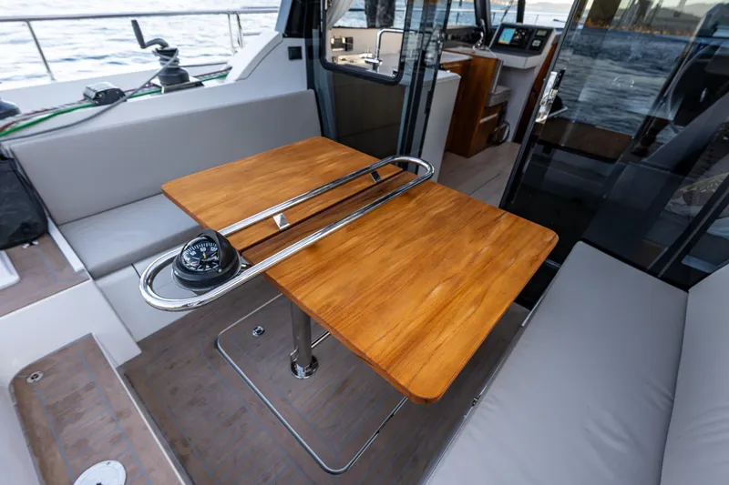 Slide: The Image of 2024 Moody 41ds yacht interior with wooden table and compass, overlooking the sea. - 10