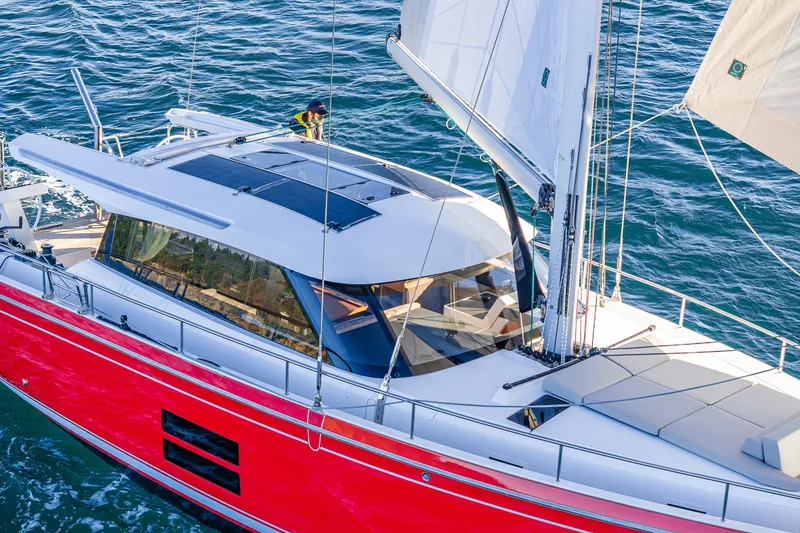 Slide: The Image of 2024 Moody 41ds sailboat with red hull, sleek design, and spacious deck on open water. - 34