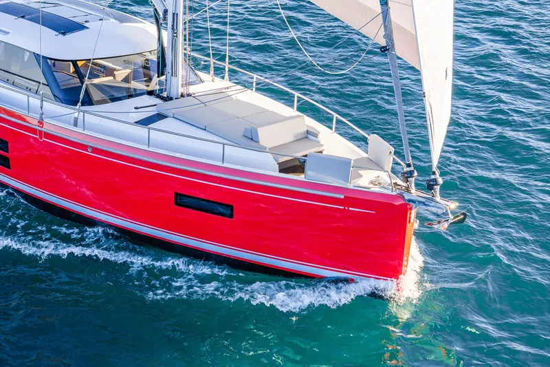 Slide: The Image of 2024 Moody 41ds sailboat with vibrant red hull sailing on blue ocean waters. - 35
