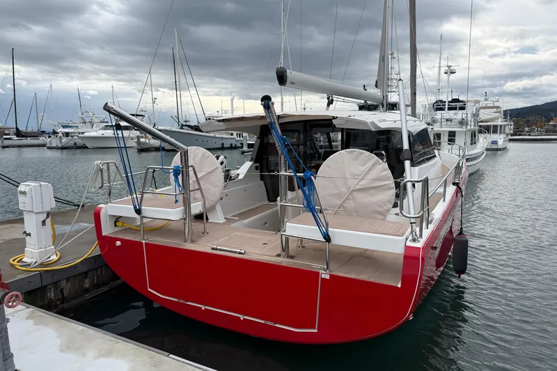 Slide: The Image of 2024 Moody 41ds sailboat with red hull docked at marina under cloudy sky. - 39